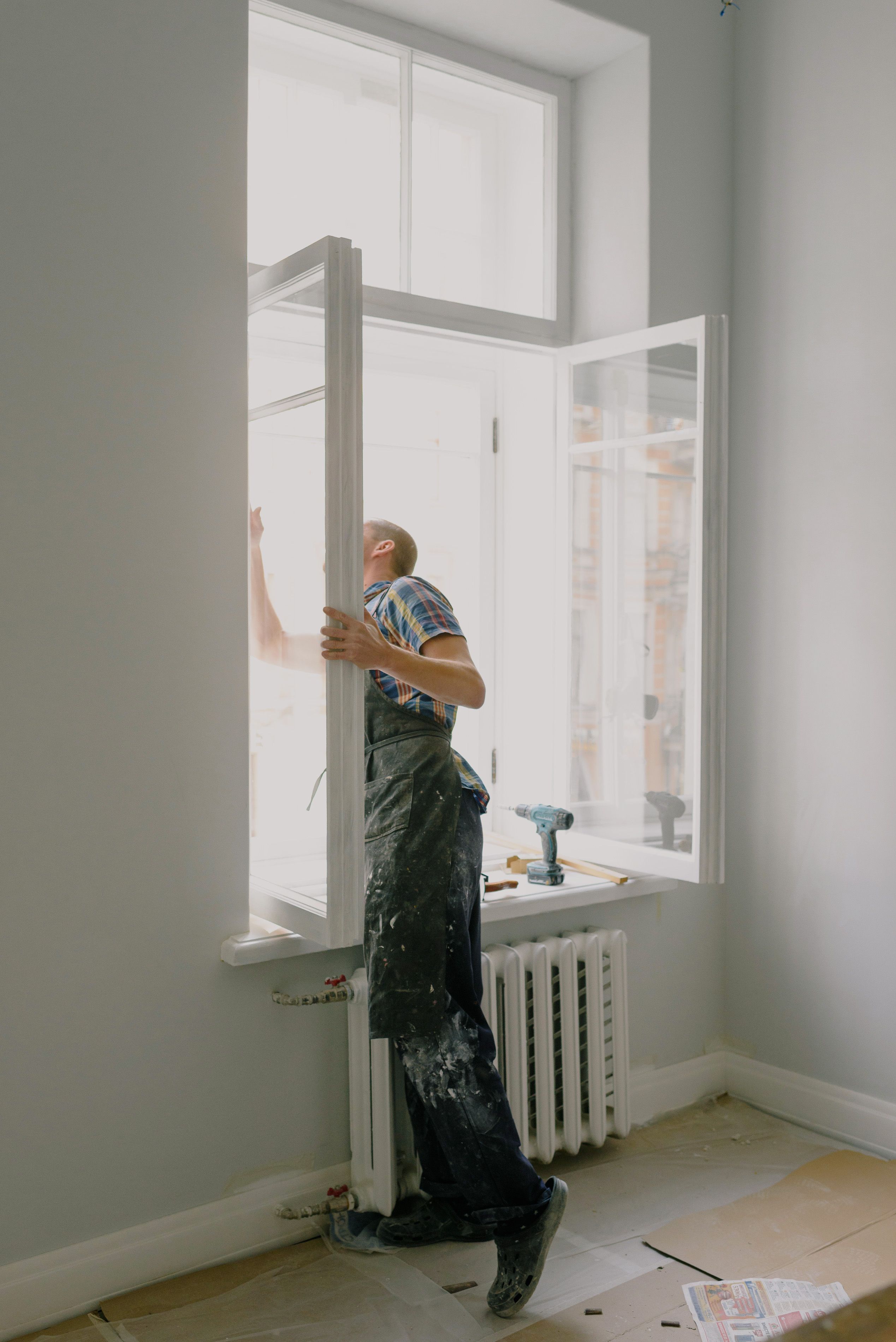 Installer positioning a window frame during home renovation