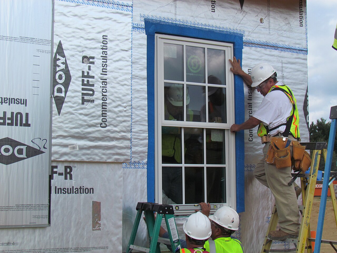 Window professionals installing a window at a NIST net-zero energy residential test facility